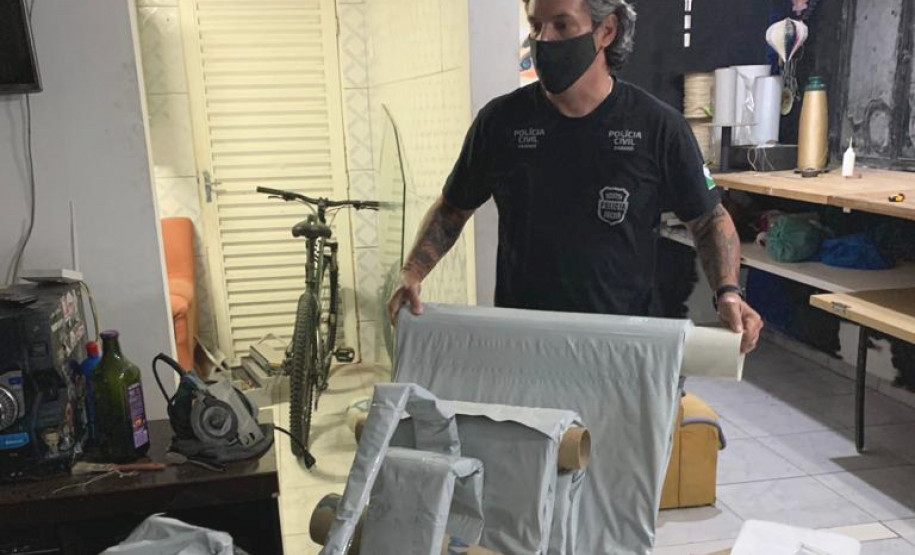 Policial civil segurando material apreendido