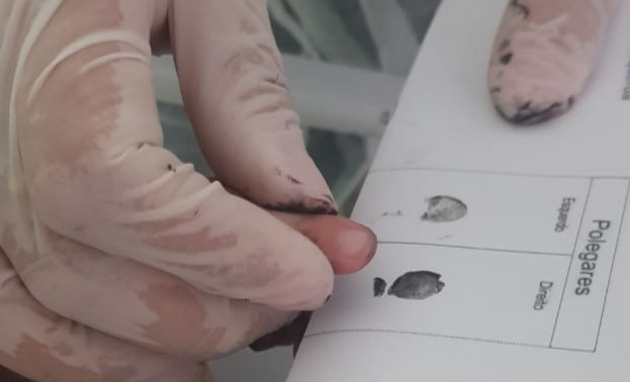 Policial colhendo a impressão digital da bebê