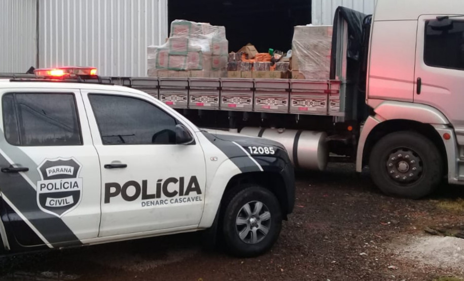 Viatura estacionada ao lado de caminhão carregado