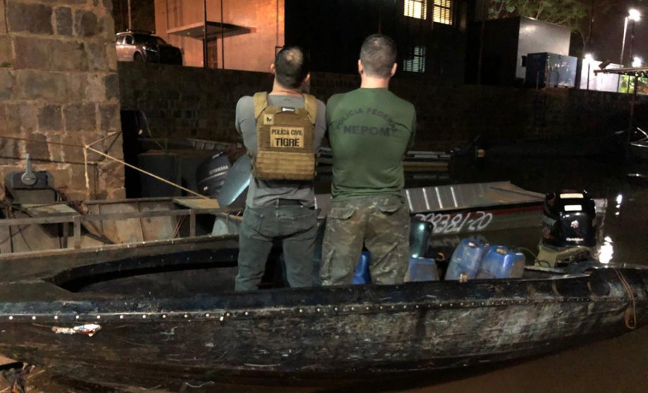 Policiais de costas, dentro do barco