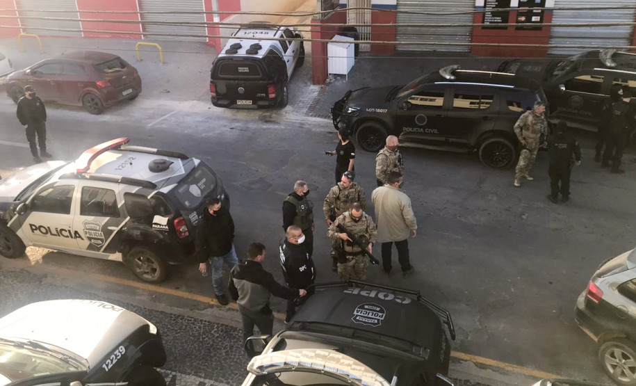 Policiais civis na rua, reunidos antes da operação