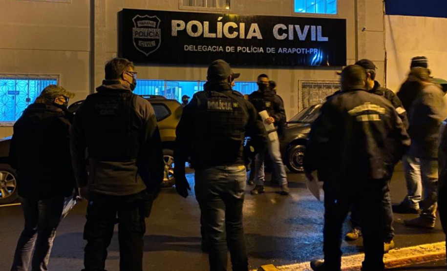 Policiais civis reunidos em frente à delegacia, recebendo instruções para a operação