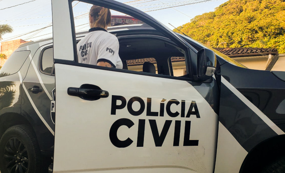 Policial civil entrando em viatura