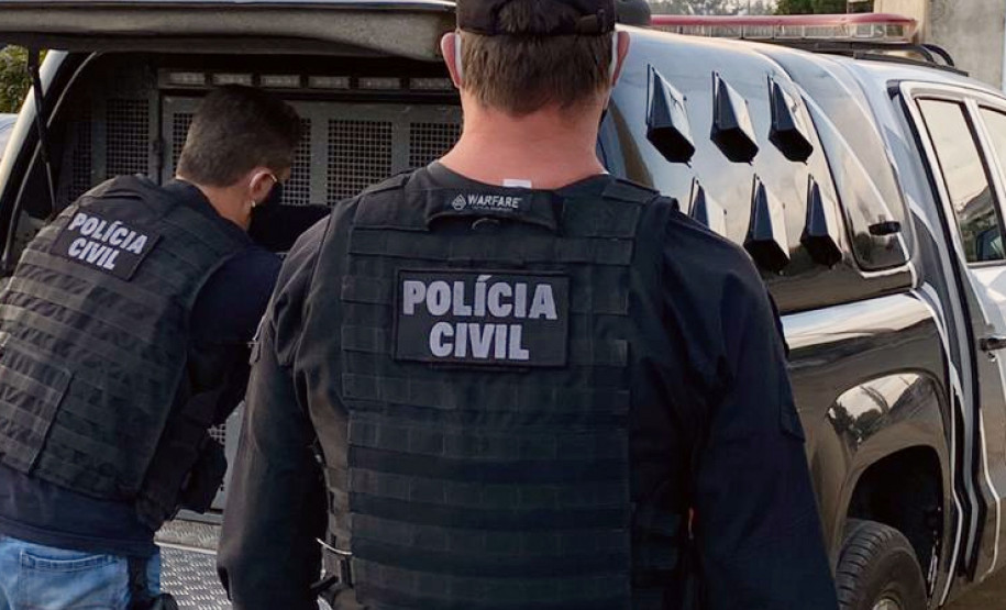 Policiais civis ao lado de viatura