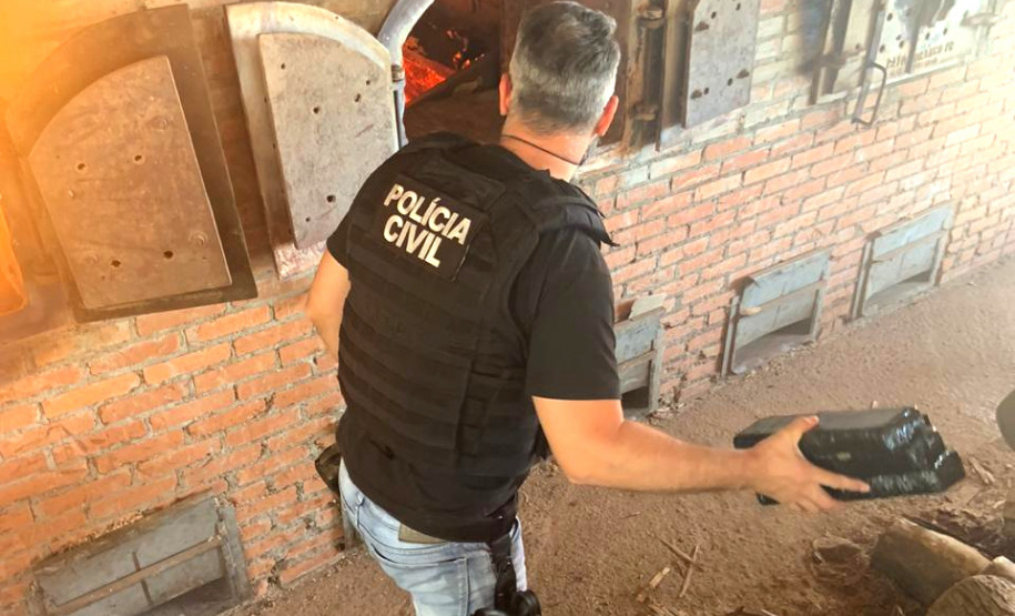 Policial jogando tabletes de droga no incinerador