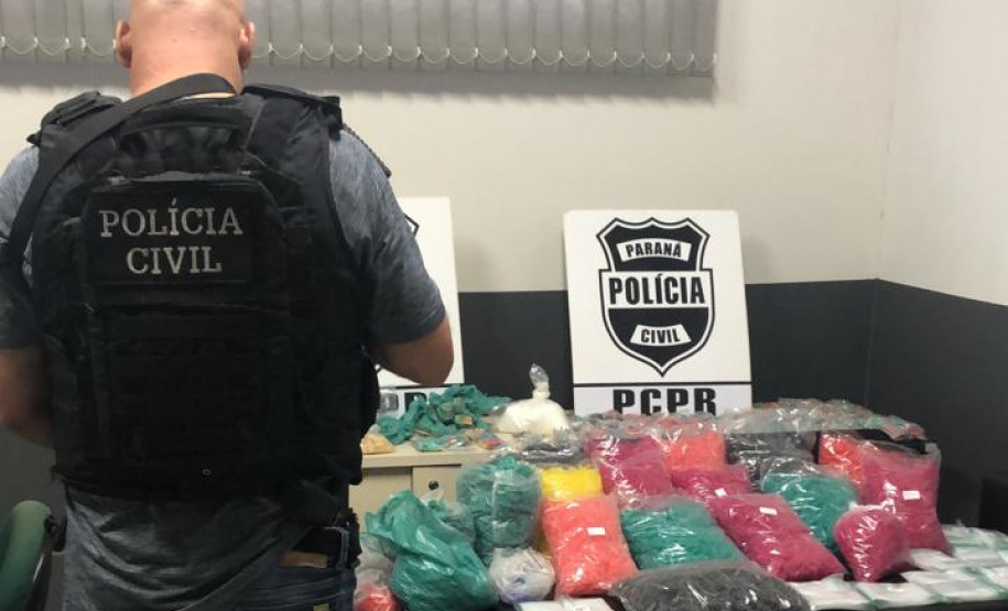 Policial civil ao lado de material apreendidos