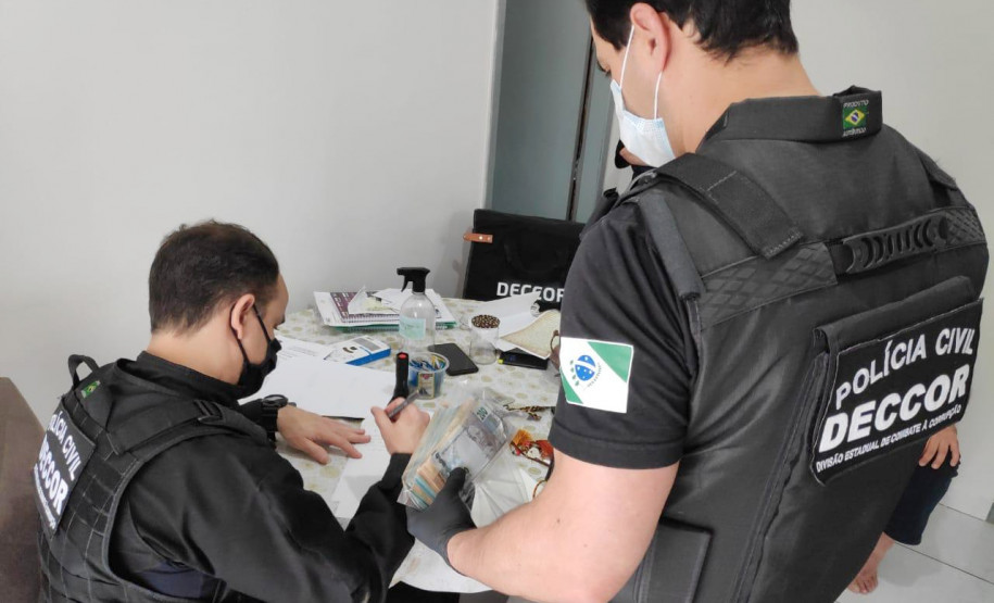 Policiais civis analisando material