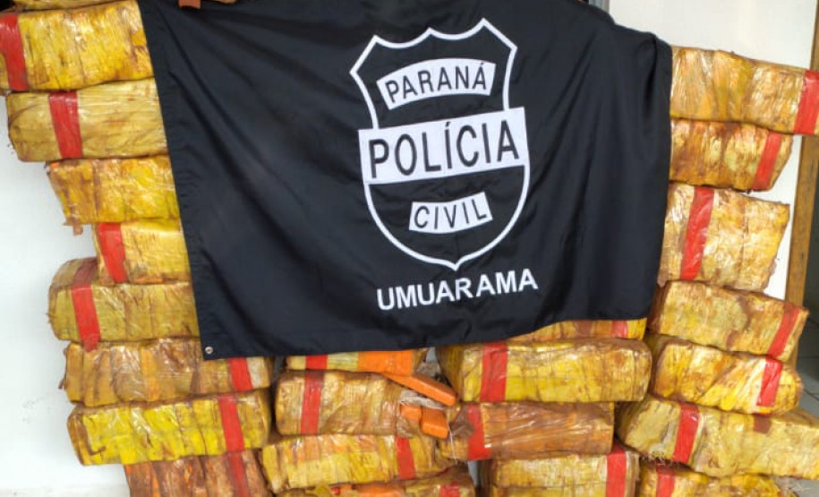 Diversos pacotes de droga empilhados, com um brasao da policia civil por cima