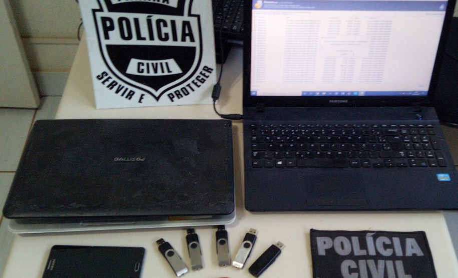 Laptops, celular e pendrive sobre uma mesa