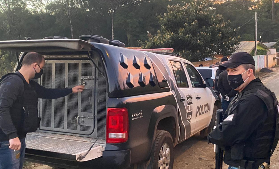 Policiais ao lado de viatura