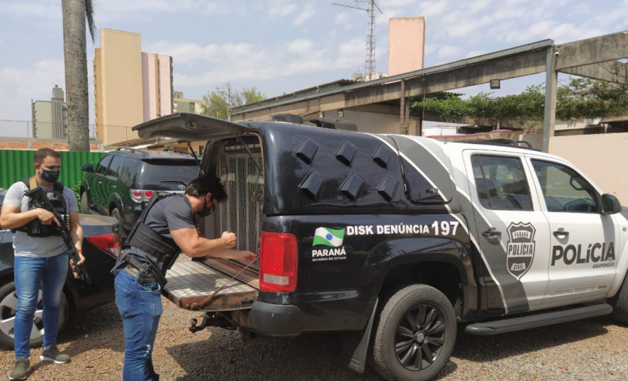 Policiais civis abrindo porta-malas de viatura