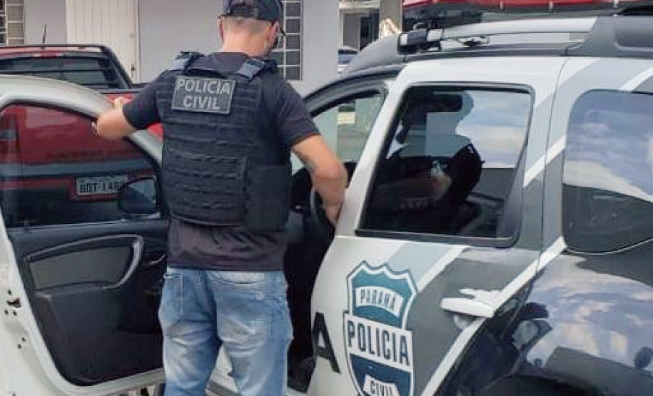 Policial civil ao lado de viatura