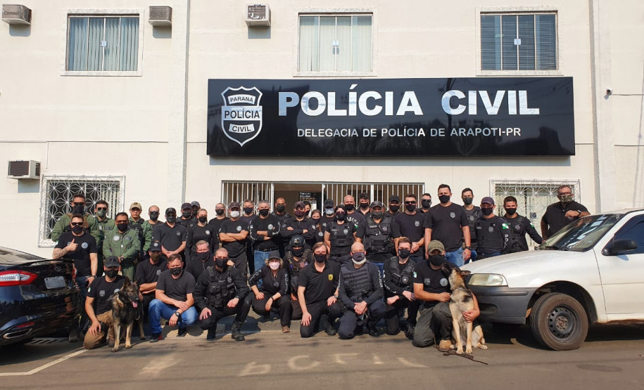 Dezenas de policiais civis posando para foto em frente à delegacia