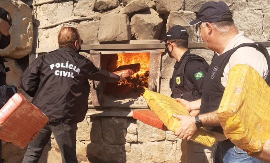 Policiais civis incierando pacotes de droga apreendida