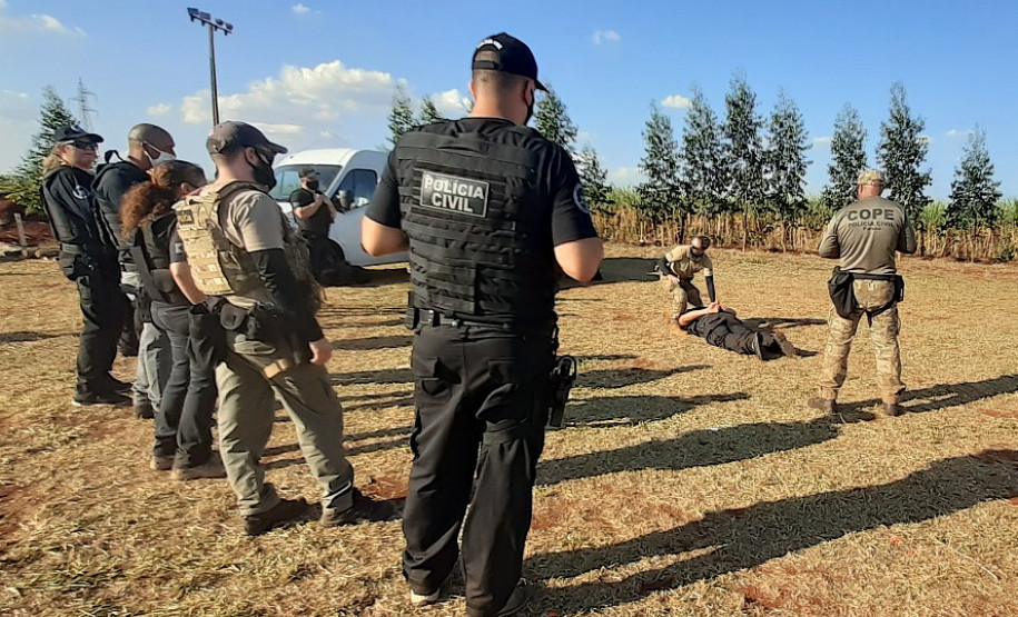 Policiais civis em pé observando  técnicas de algemamento
