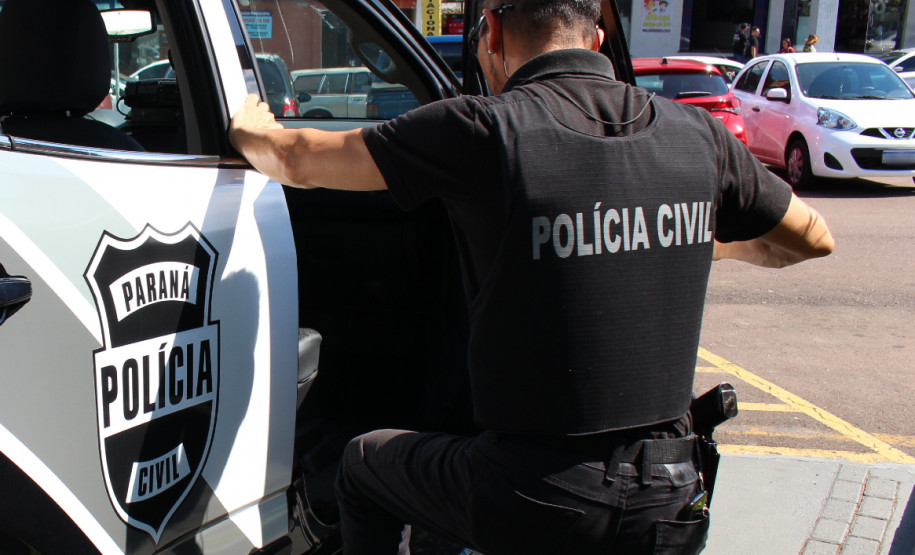 Policial civil entrando em viatura