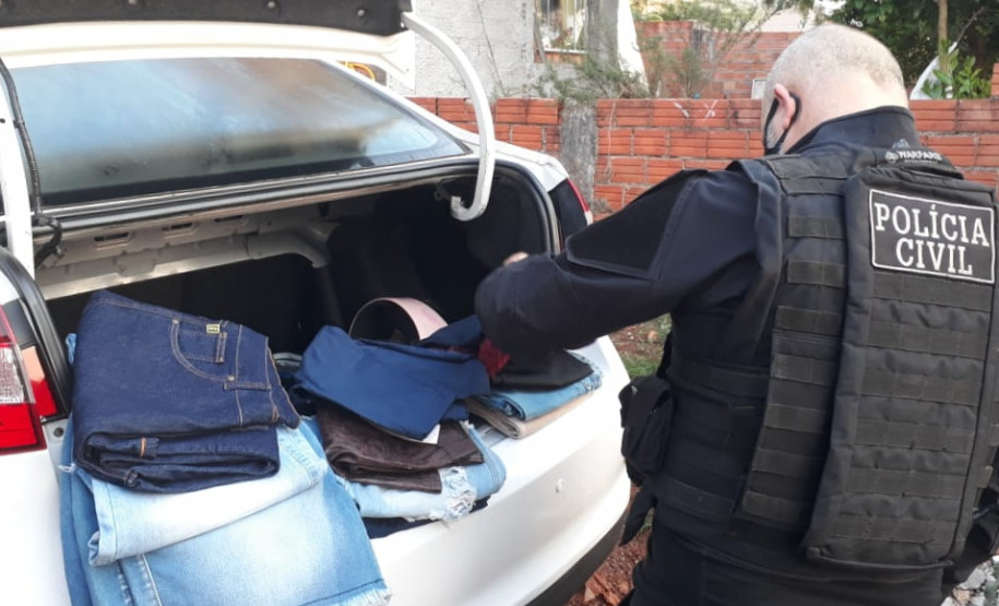Policial civil com material apreendido, no porta-malas de um veículo