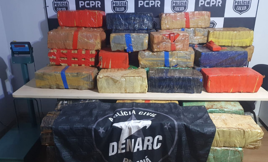 Tabletes de droga empilhados no chão e sobre uma mesa.