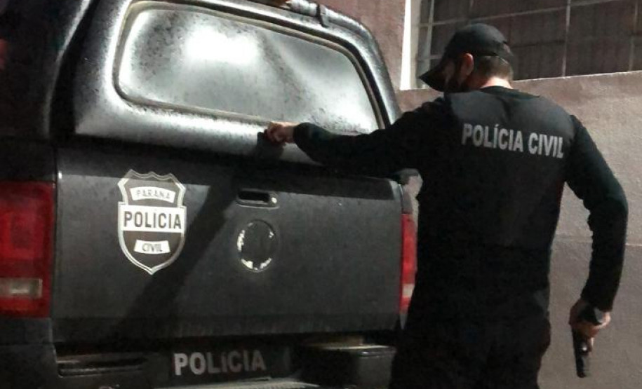 Policial civil empunhando arma e fechando tampa do porta-malas de viatura