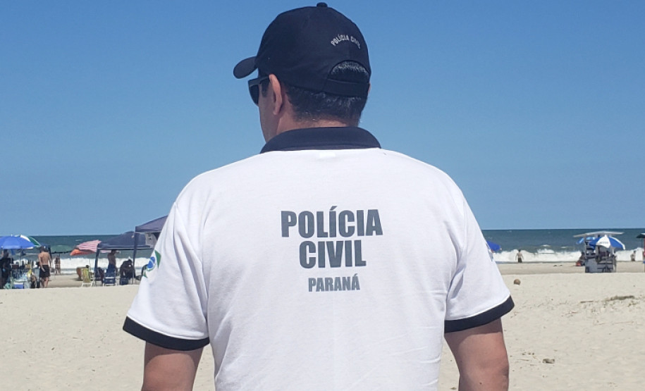 Policial de costas observando beira-mar