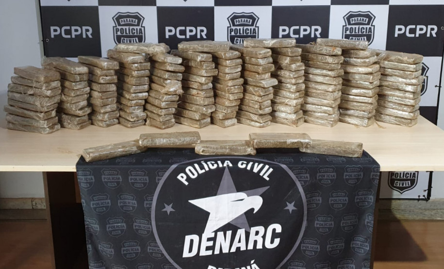 Diversos tabletes de droga empilhados sobre uma mesa.