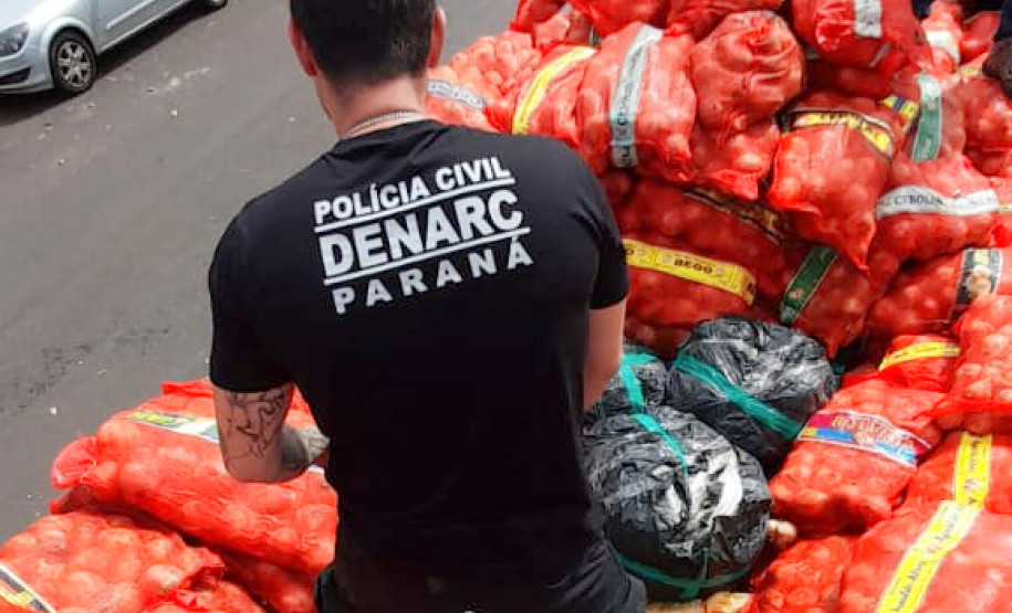 Policial civil investigando local com a carga