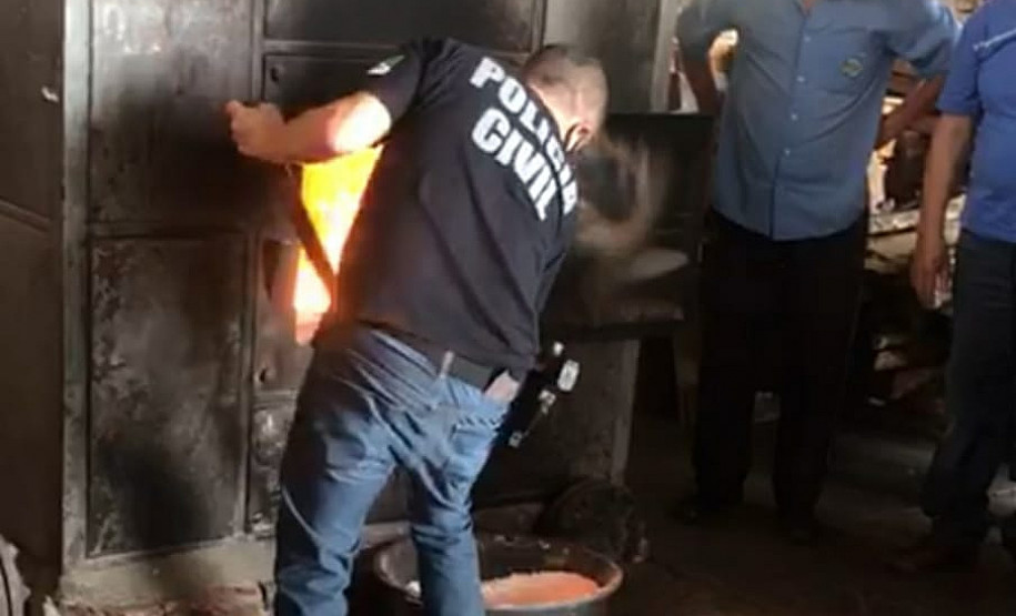 Policial civil jogando material apreendido no incinerador