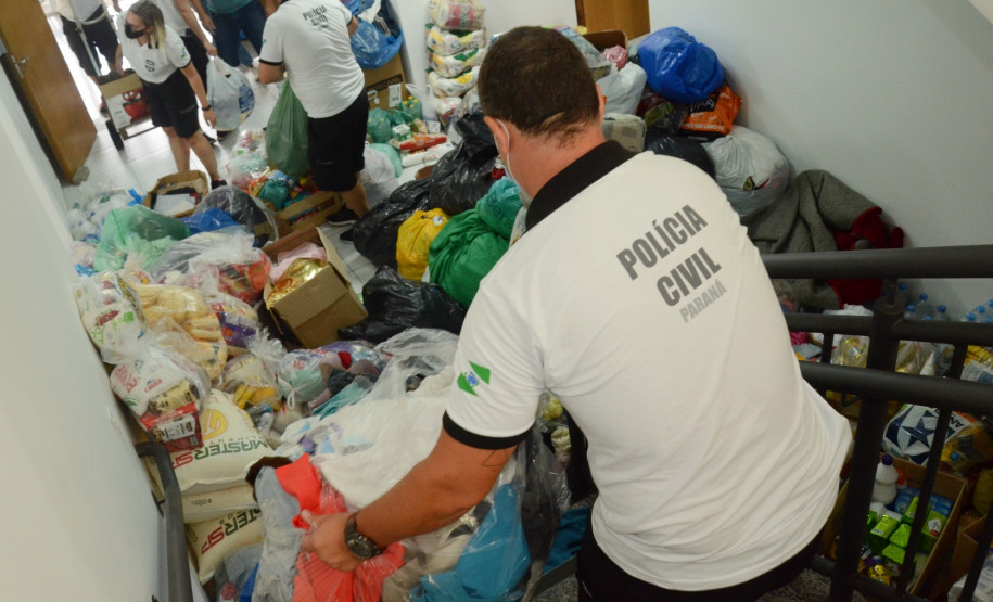 Policiais civis organizando produtos arrecadados para carregamento em caminhao