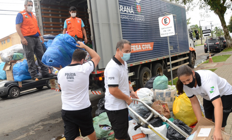 Policiais civis carregando em caminhao produtos arrecadados