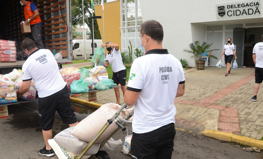 Policiais civis carregando caminhao com produtos arrecadados