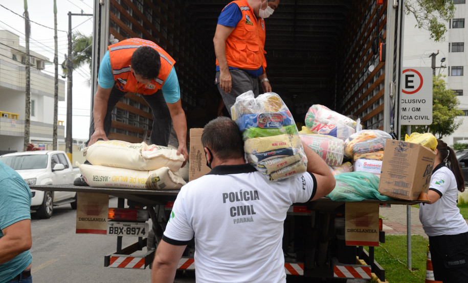 Policiais civis carregando em caminhao produtos arrecadados