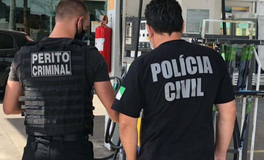 Policial e perito colhem amostra em posto de combustível