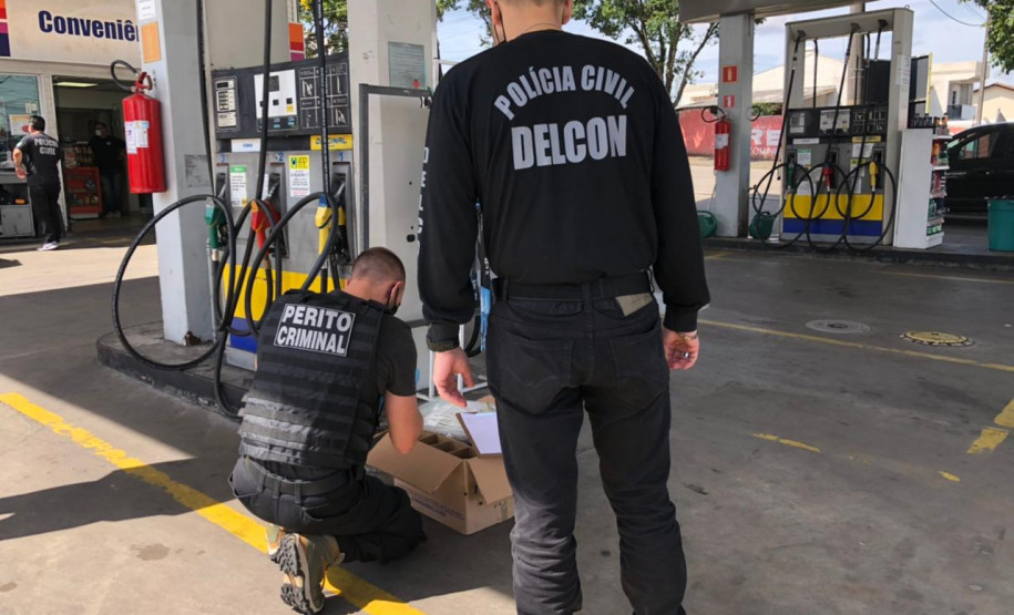 Policiais e perito colhem amostra em posto de combustível