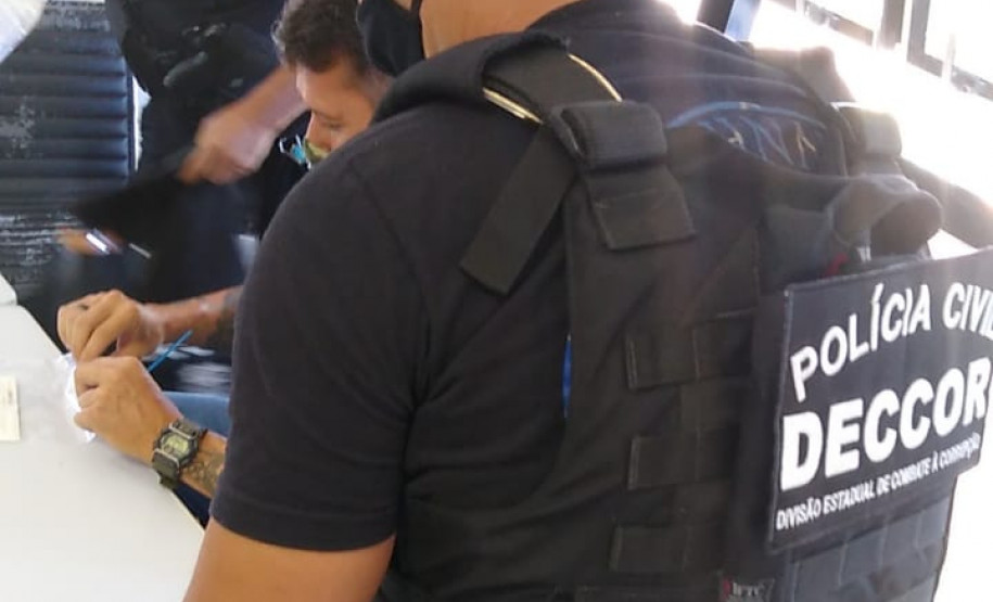 Policiais civis analisando material apreendido