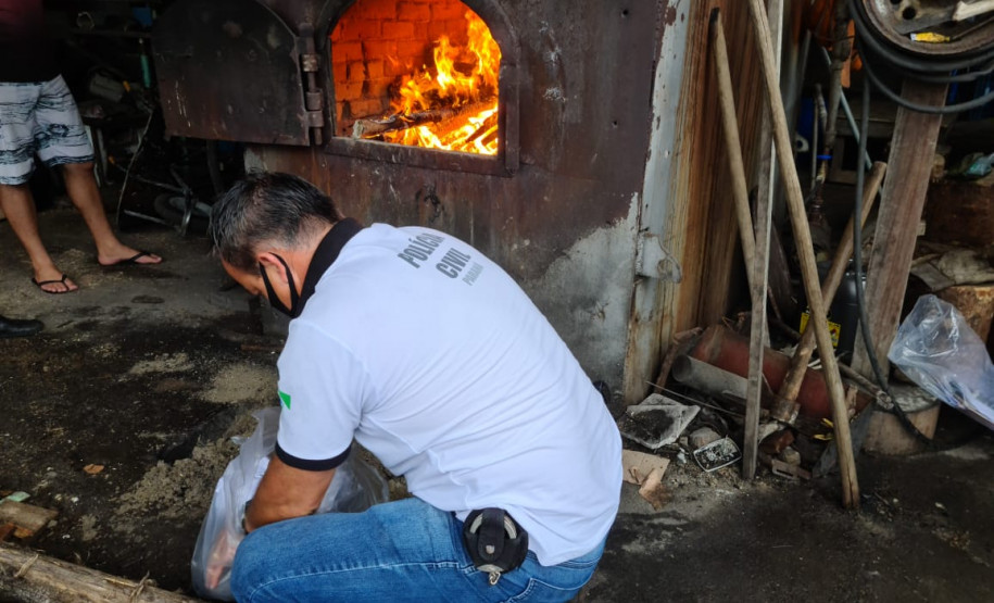 Policial em frente ao forno de incineração