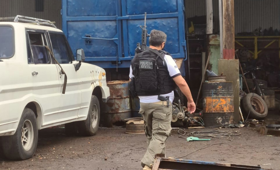 Policial civil armado com fuzil e pistola, entrando em estabelecimento