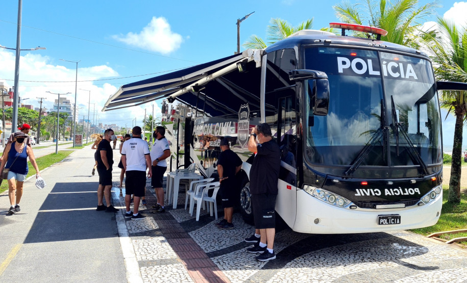 Onibus com delegacia móvel estacionado no litoral e vários policiais civis à disposição para atender a população