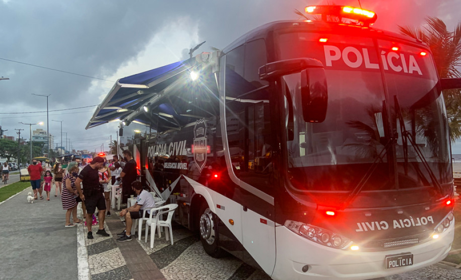 Onibus com viatura móvel estacionado e policiais civis atendendo veranistas