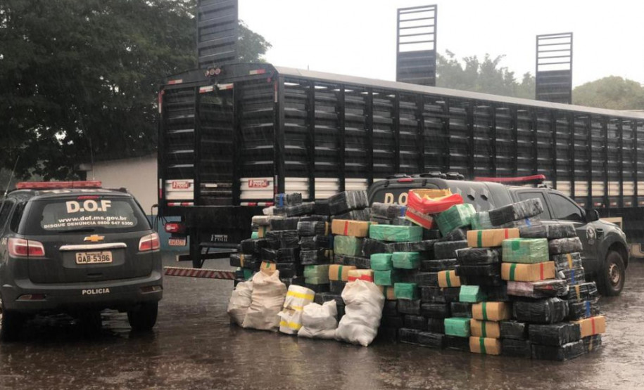 Pacotes da droga empilhados ao lado de caminhão