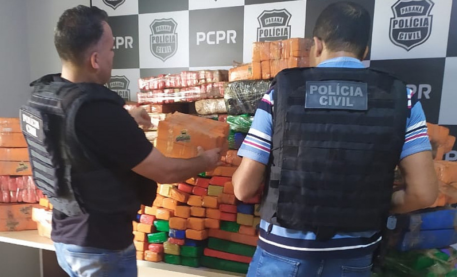 Policiais civis empilhando tabletes de droga apreendida