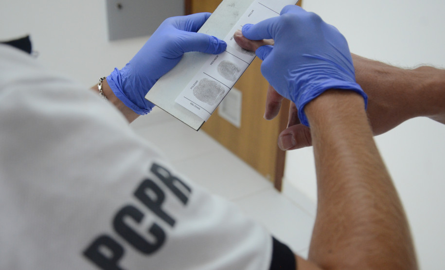 Policial civil recolhendo digitais