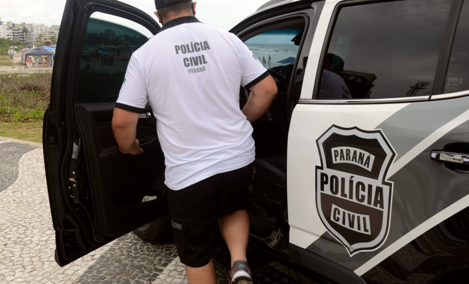 Policial civil entrando em viatura