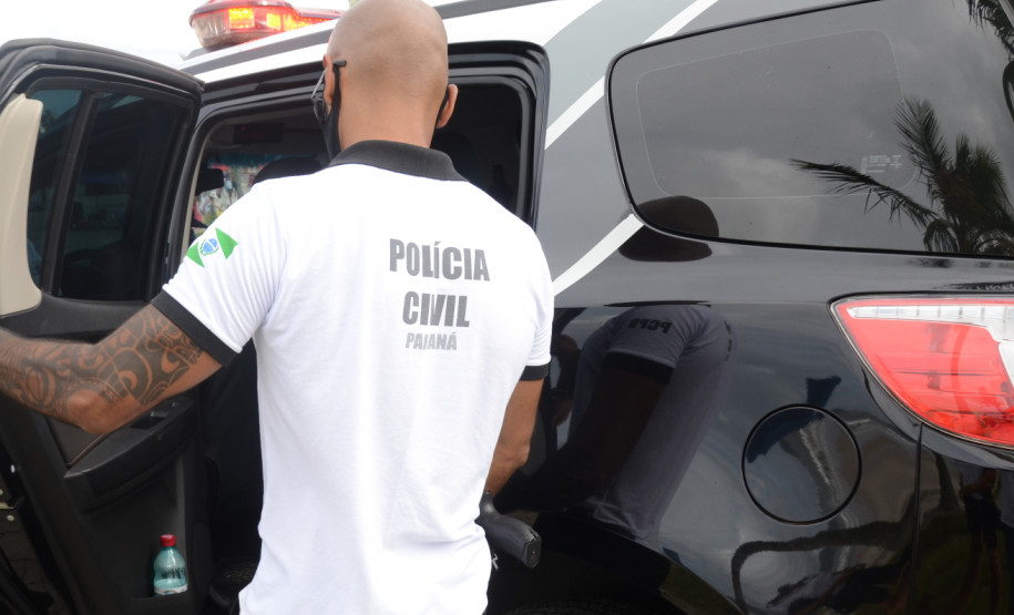 Policial civil entrando em viatura
