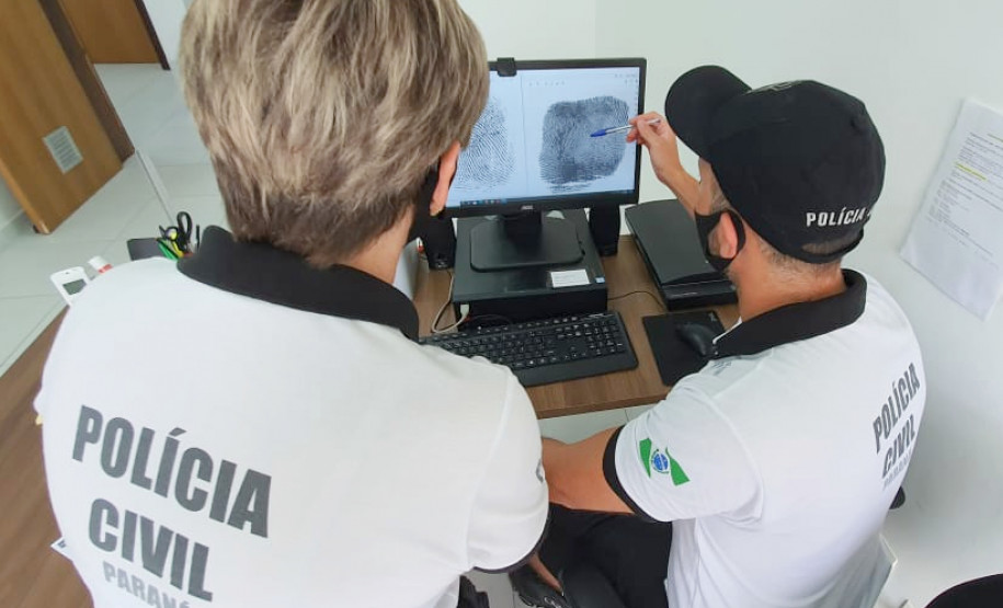 Policiais civis analisam digitais em tela de monitor