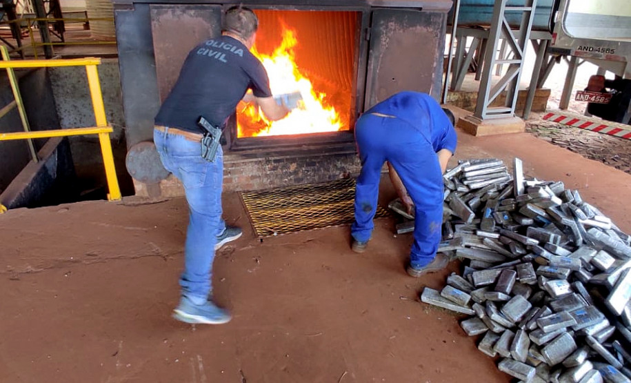 Policial civil e funcionário do local jogando tabletes de droga no incinerador