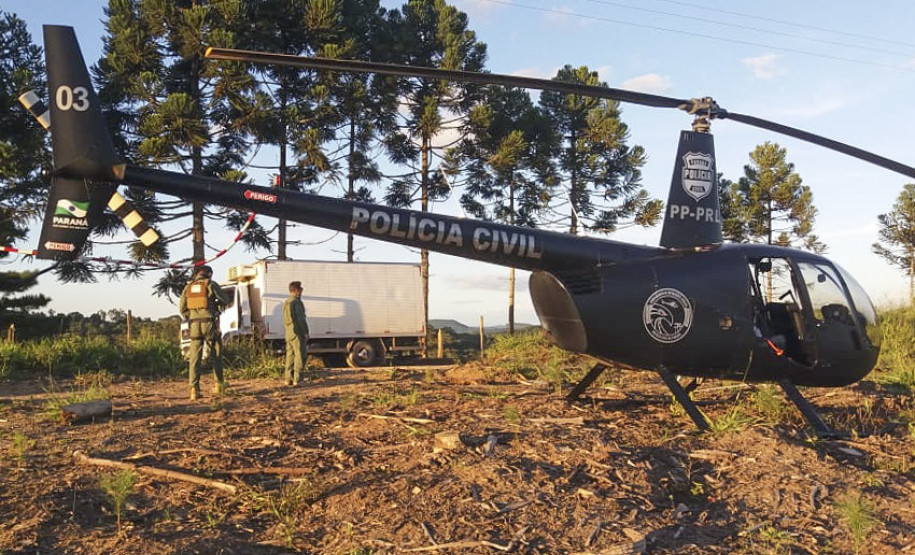 Em primeiro plano, helicóptero da PCPR. Ao fundo, policiais e caminhão roubado.
