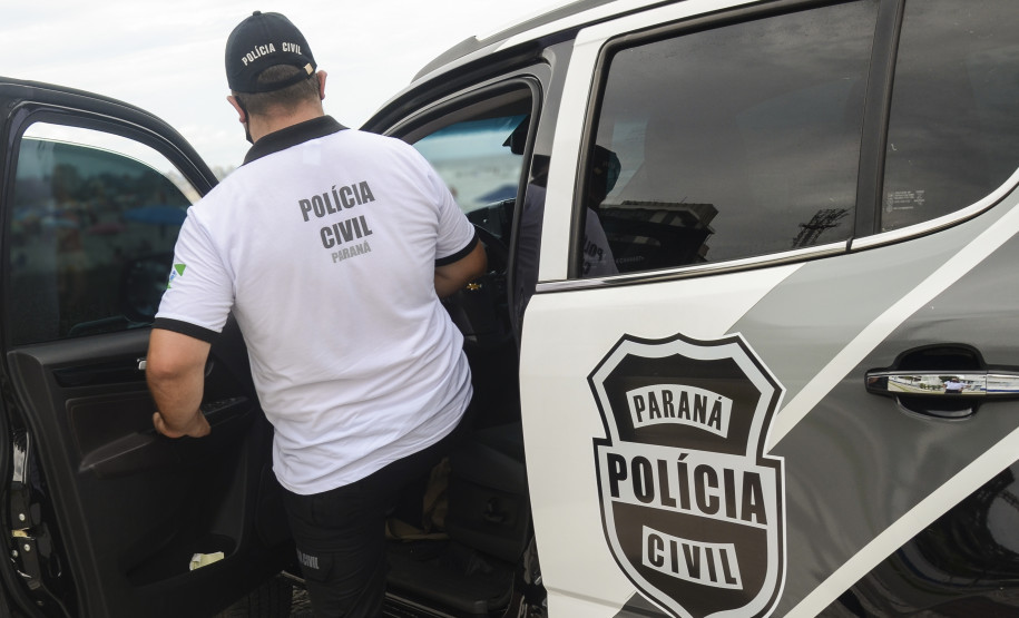 Policial civil entrando em viatura