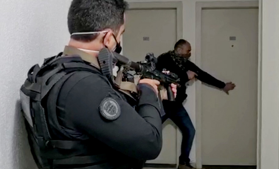 Dois policiais civis empunhando armas em momento da operação