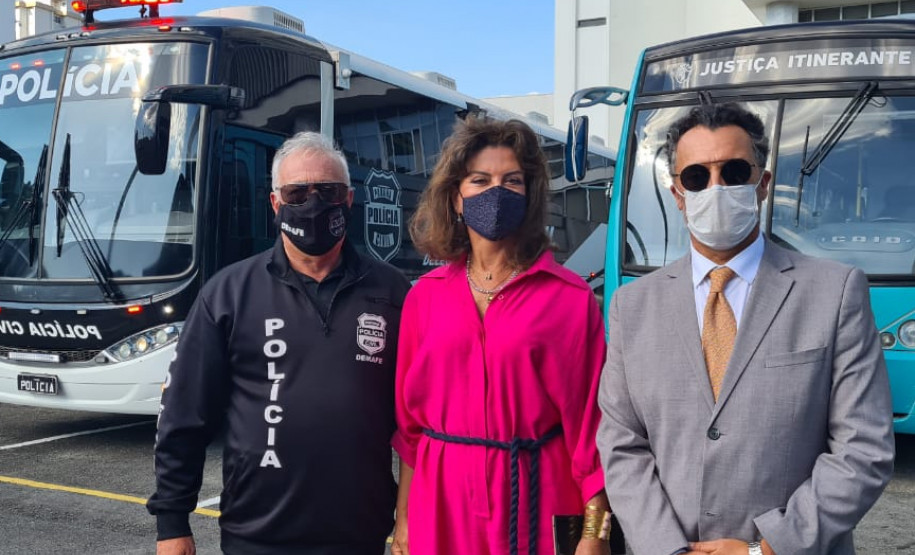 Envolvidos no projeto posando para foto em frente aos ônibus da PCPR e TJ