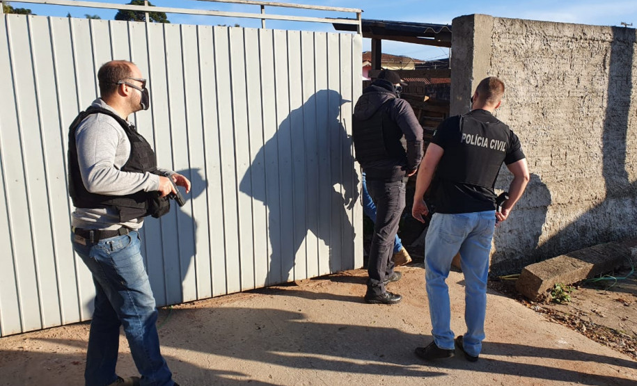 Policiais civis na calçada, acessando local